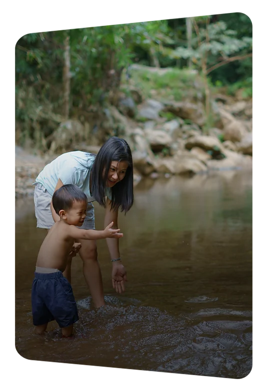 A parent and child beside a river